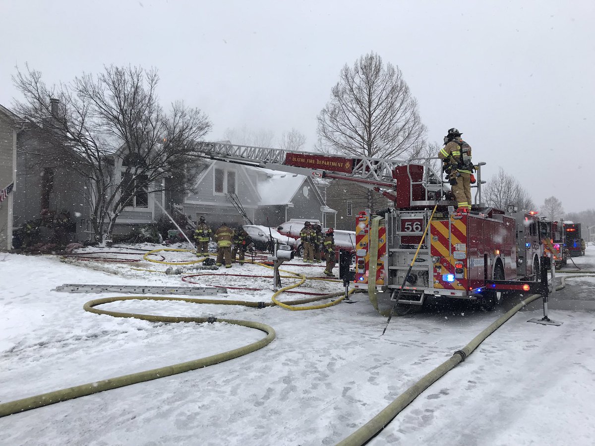 @OlatheFire continues to put water on a house fire. A captain said lots of stuff inside fueled the fire, causing it to spread  Firefighters rescued 1 adult from the front window. 2 other adults and a teenager escaped on their own. All are at the hospital and are stable