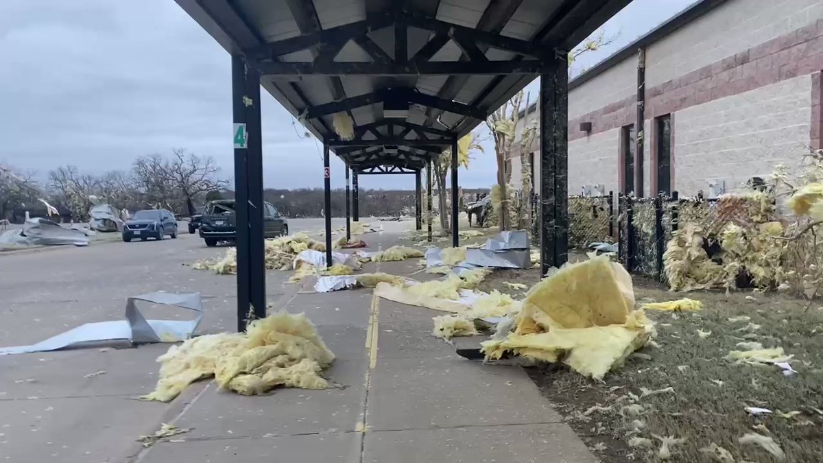 Shredded insulation covers the parking lot outside Jacksboro Elementary after a suspected tornado tore through the area yesterday