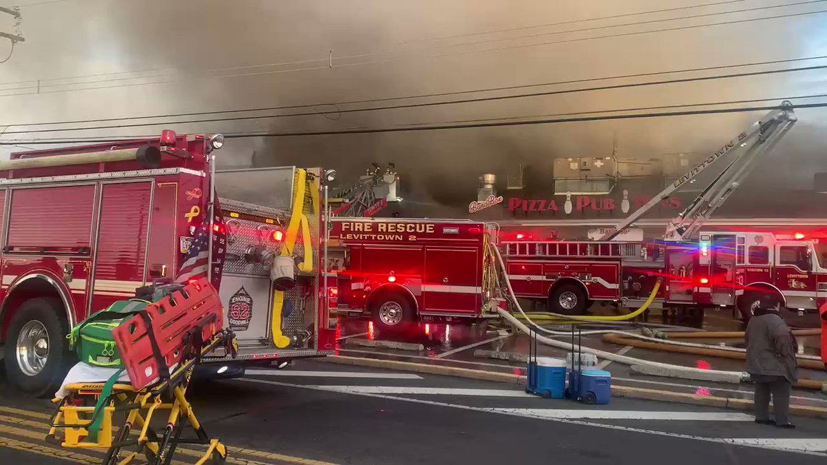 The Fire has now spread to the last bit of the bowling alley that was left standing, the front, where the bar and live bad area was by front door of Levittown Lanes where extremely thick overtook firefighters on a ladder who came down to get out of the smoke