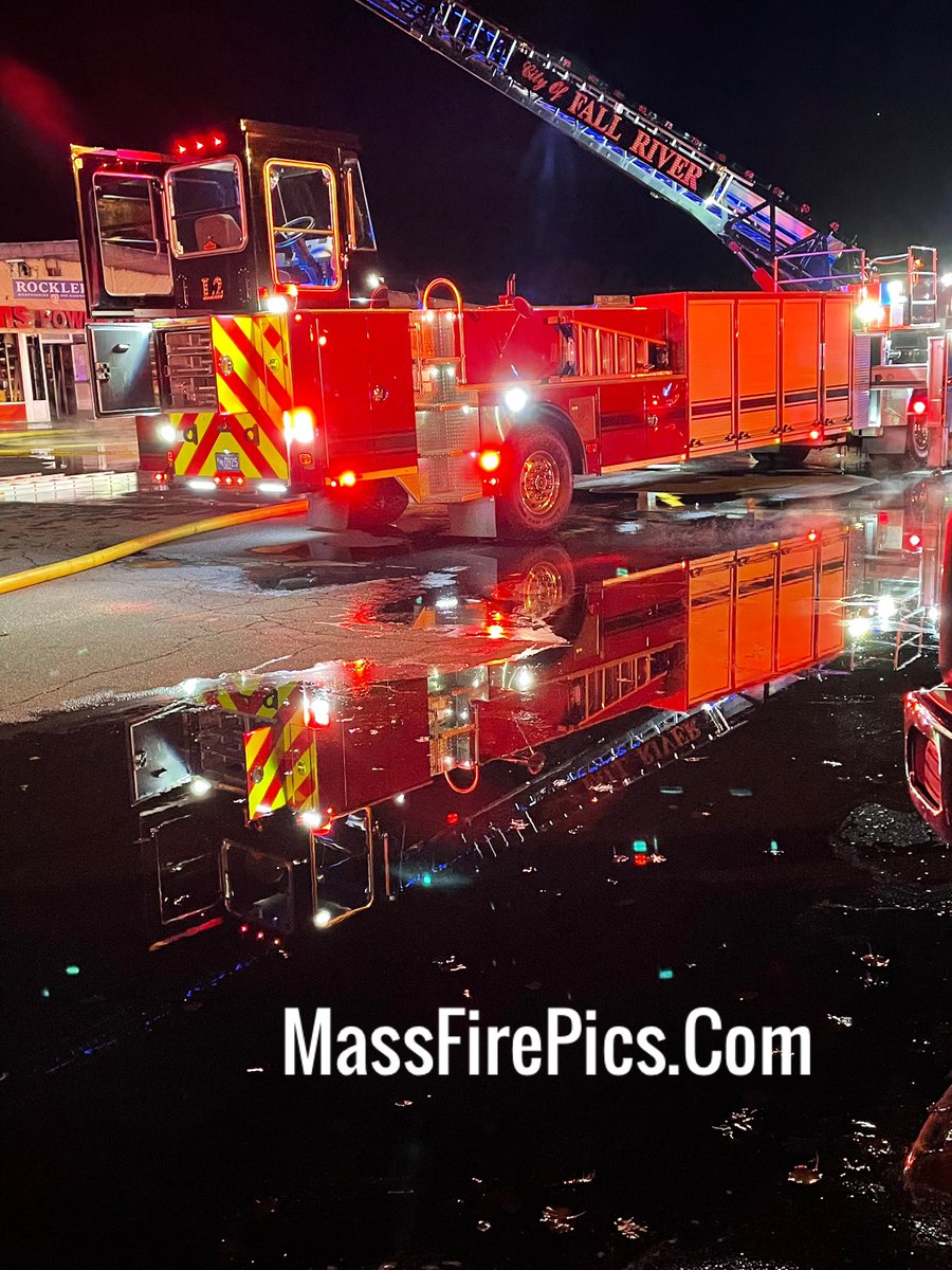 Fall River Ma. still burning, extended operations.  Fall River Ladder-2 reflection in the water