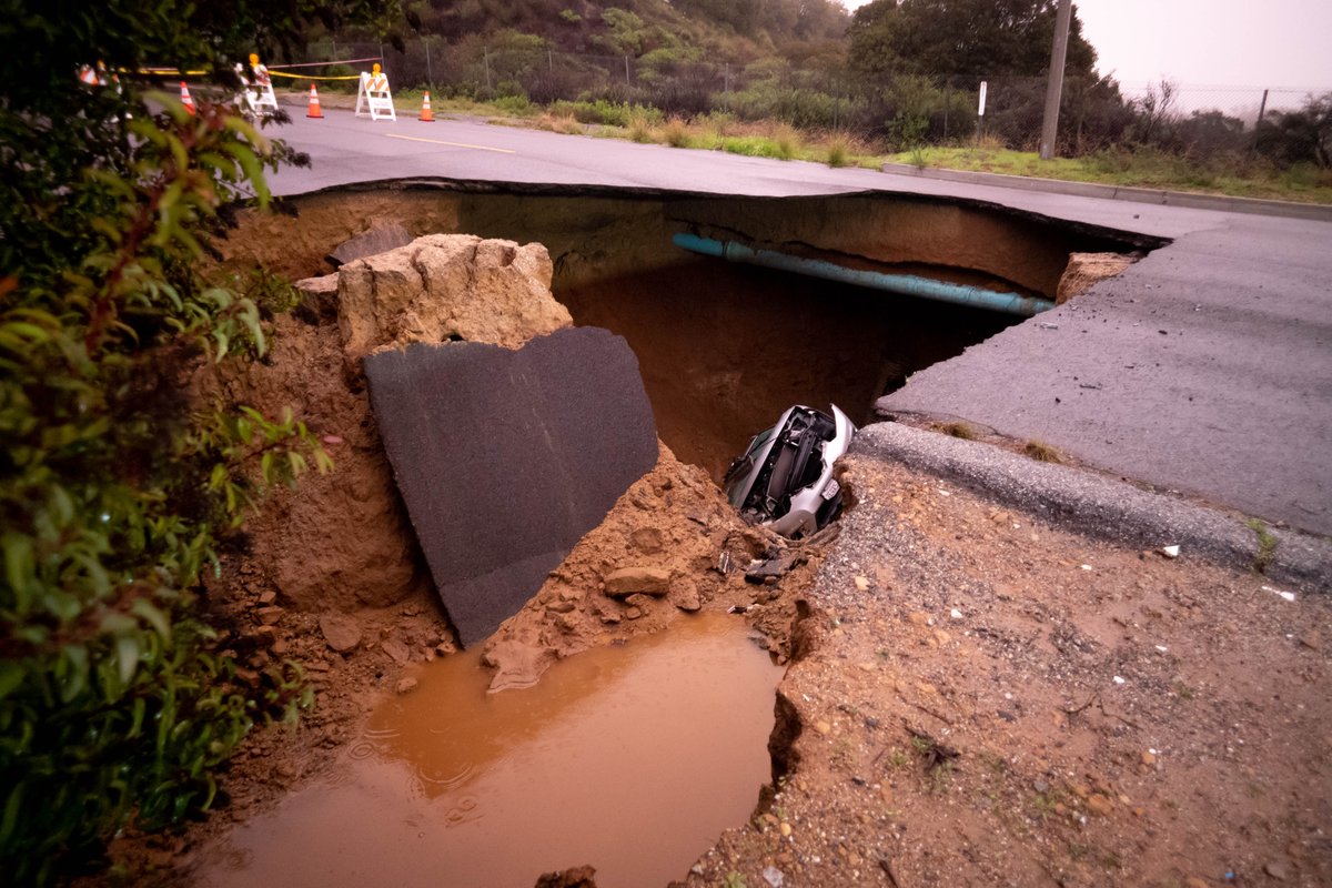 Cars remain in a large sinkhole along Iverson Road in Chatsworth Tuesday. A woman and a young girl are recovering after being trapped inside one of the vehicles   Monday night.  Los Angeles Fire Department rescuers pulled the victims to the surface