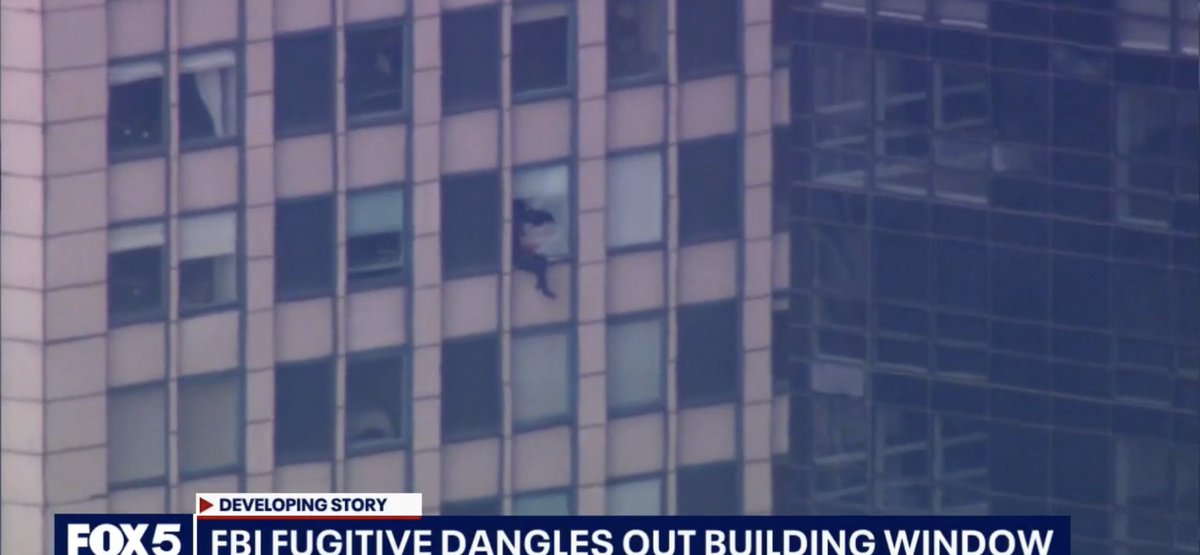 Suspect wanted by the FBI broke thru a window in a Manhattan high rise and is now just sitting there.  Air cushion set up below