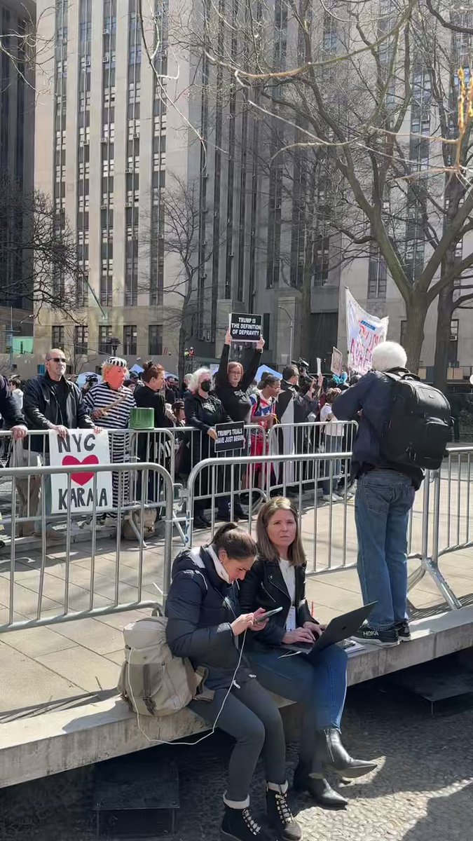 Anti and pro-Trump protesters in front of the Manhattan courthouse, divided by a fence and surrounded by hundreds of reporters