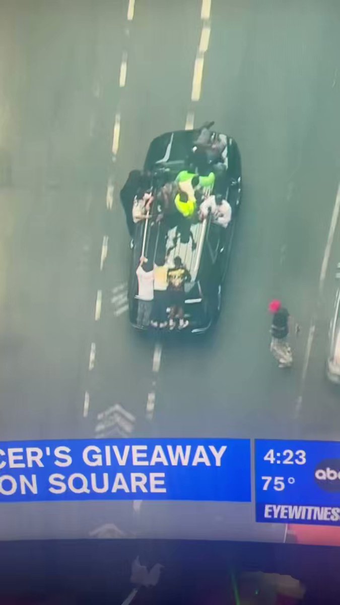 Several people hold onto a vehicle fleeing NYC's Union Square