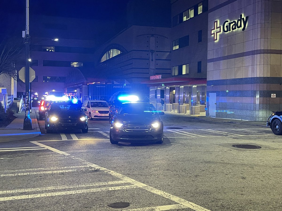 APD officers escort body of officer killed overnight from Grady to Medical Examiner's office. Chief tells us officer suffered medical emergency on his way to work.