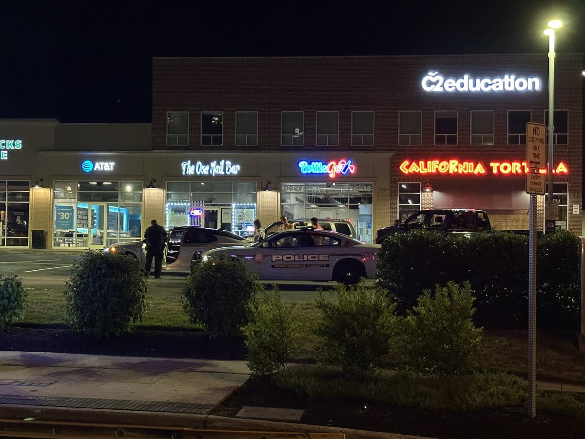 WOMAN MISTAKENLY SHOT AT: Lockwood Drive and Columbia Pike (Route 29) in Silver Spring  the woman is speaking with policemen now in the Cal Tort lot after her car was struck by several bullets