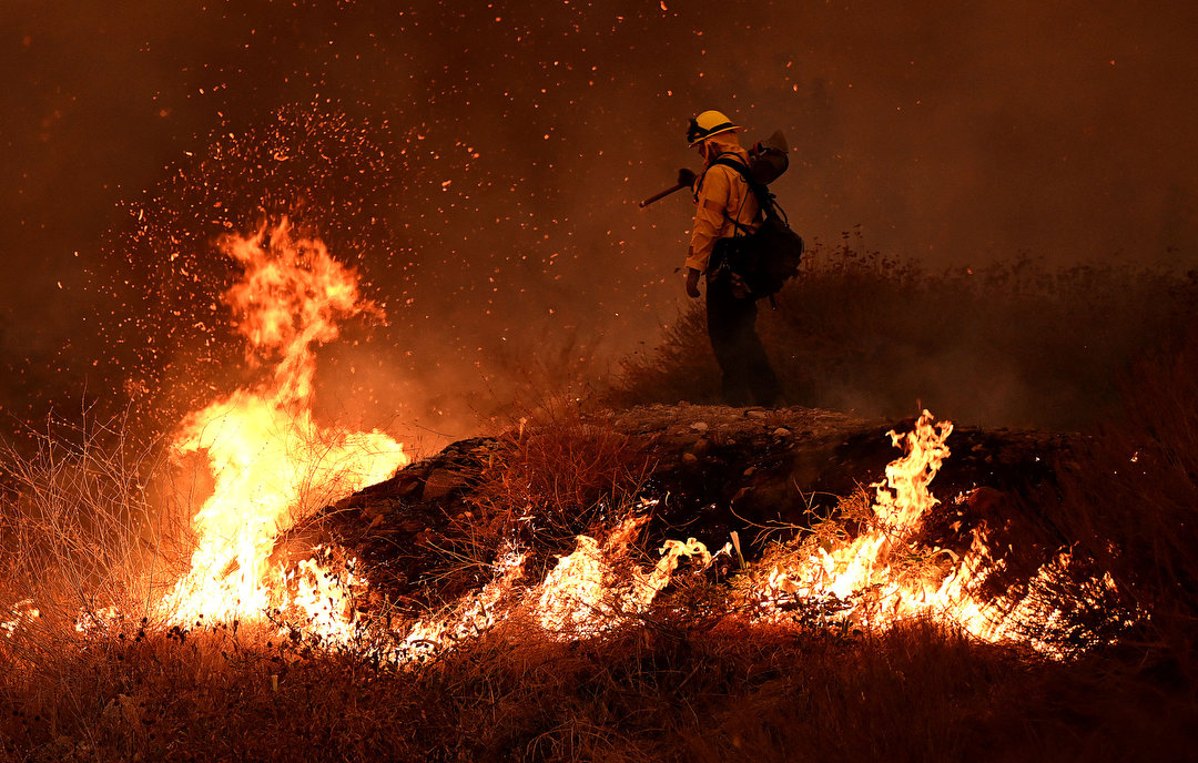 Firefighters try to keep the Line fire away from homes on Emmerton Lane in Highland on Saturday evening Sep. 7, 2024.