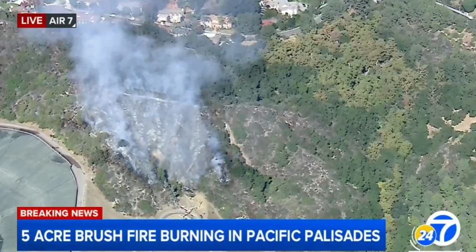 Firefighter helicopters continue to make water drops on wildfire near homes in Pacific Palisades