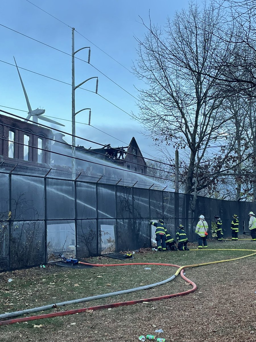 Firefighters still spraying water on the vacant warehouse on Forbes St in Chelsea. Part of the building has collapsed and with concern that more might collapse onto the MBTA Commuter Rail tracks, the Newburyport/Rockport line has been suspended until further notice