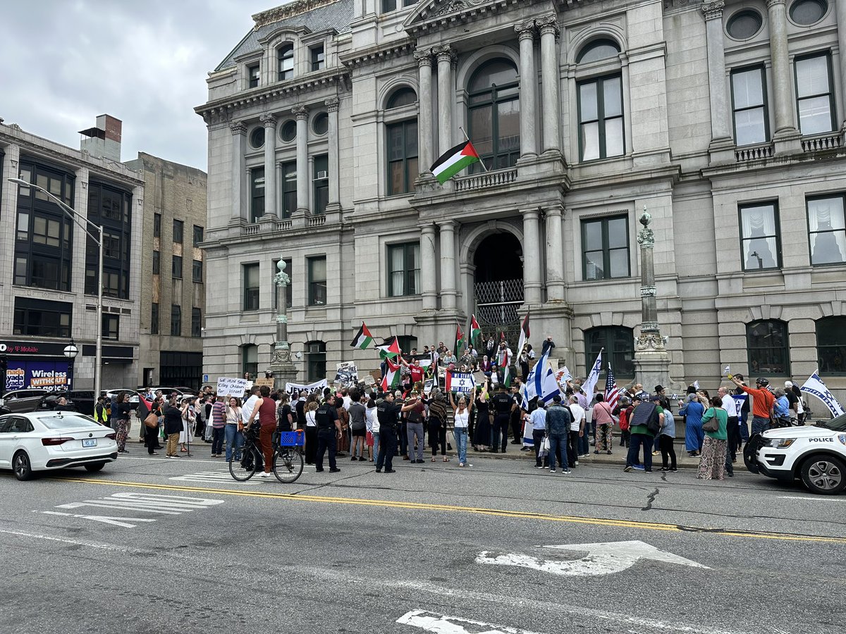 A large crowd has formed in front of Providence City Hall as the Palestinian flag flies above. Kennedy Plaza is filled with the sound of  both sides trying to drown each other out