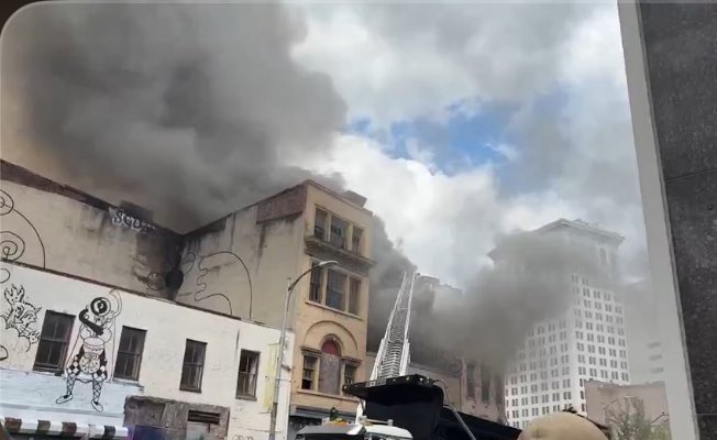 The fire has escalated to a 4th alarm and now involves another block of buildings. @mtamaryland Light Rail has been shut down.
