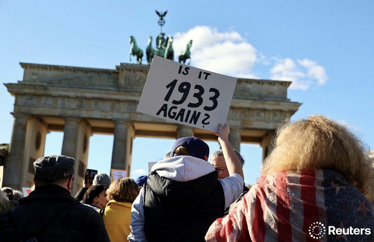 A demonstrator holds a sign to protest against U.S. President Donald Trump and his administration during a 'No Kings' rally near the U.S. embassy in Berlin, Germany, October 18, 2025. REUTERS/Christian Mang