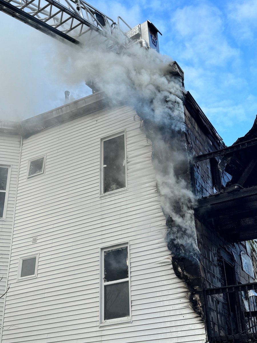 Firefighters continue to chase the fire in the eaves and roof at the 2 alarm fire on Washington st Roslindale.This is a 3 family home