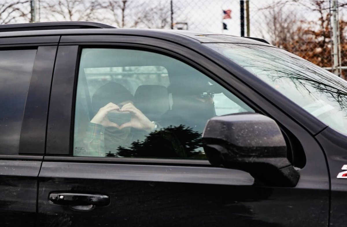 An immigration agent flashes a heart symbol at protestors as he's leaving the ICE facility in Minneapolis.    Workers going in and out of the federal building have been taunted and surrounded by anti-ice protestors for more than a week.