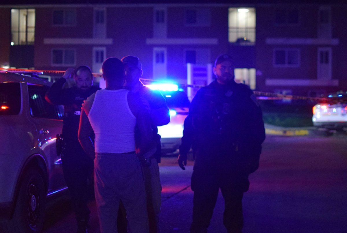 An officer deters a man from rushing into a crime scene after his loved one was shot and killed inside of the Winston Apartments on Wednesday. The violent attack sent a ripple of shock across the community