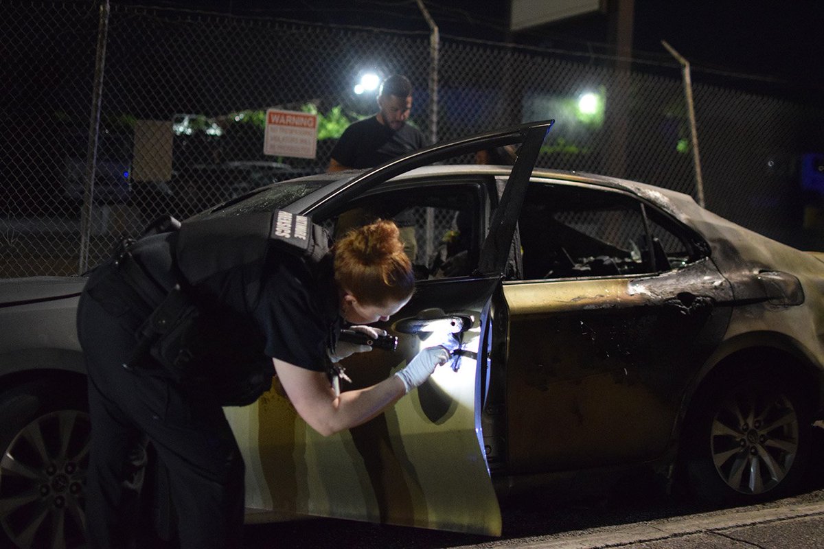 A crime lab technician dusts for fingerprints during an arson investigation on Erdman Avenue.