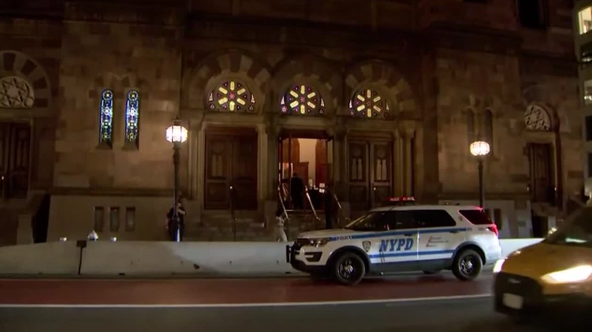 A 46-year-old suspect is accused of spitting at and headbutting a security guard during a service at a New York synagogue.