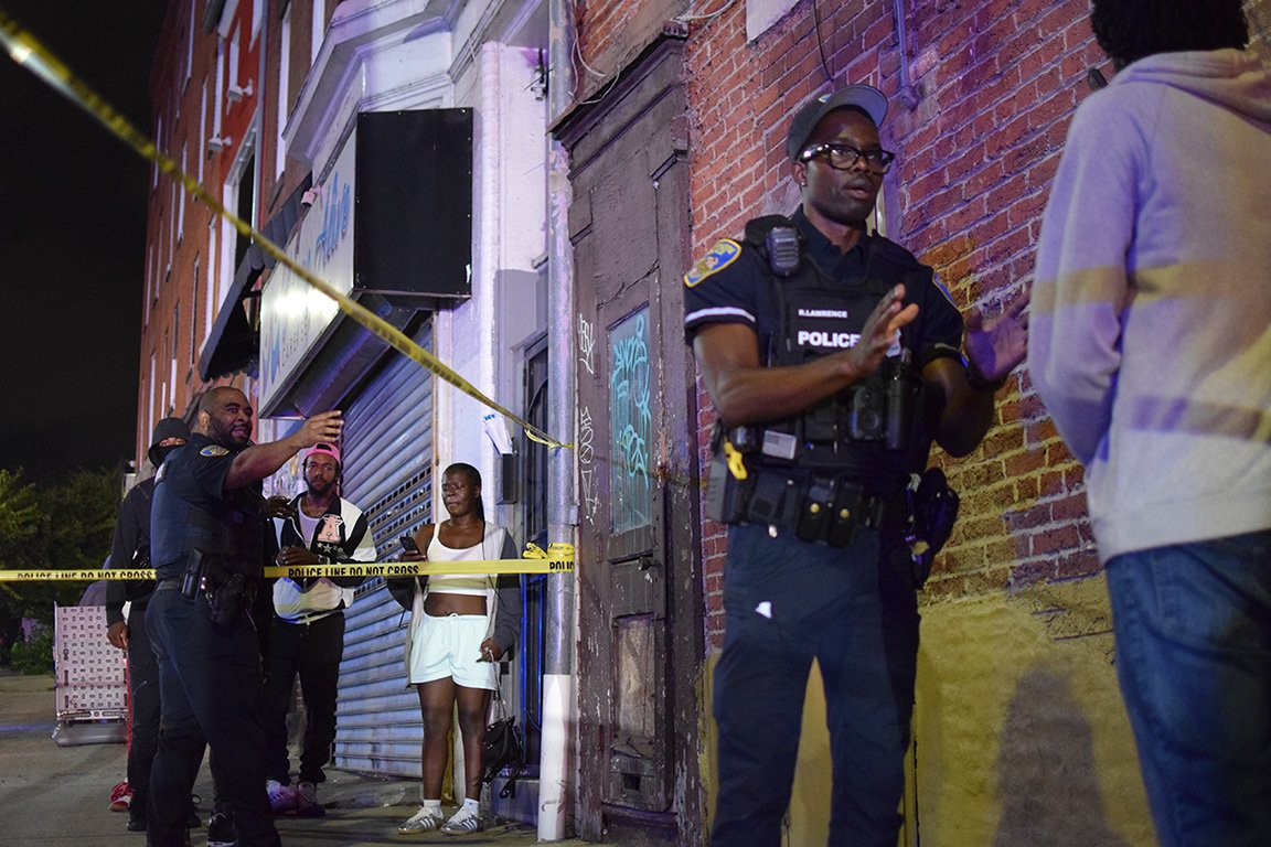 These officers did their best to remain professional, but this was a bad tape job that created unnecessary problems for them. See how the two strips of tape create a little blockade It didn't protect any evidence. It mostly just created grievances among the bystanders.Police experienced difficulties with some of the people who gathered around the crime scene aftercthe shooting.